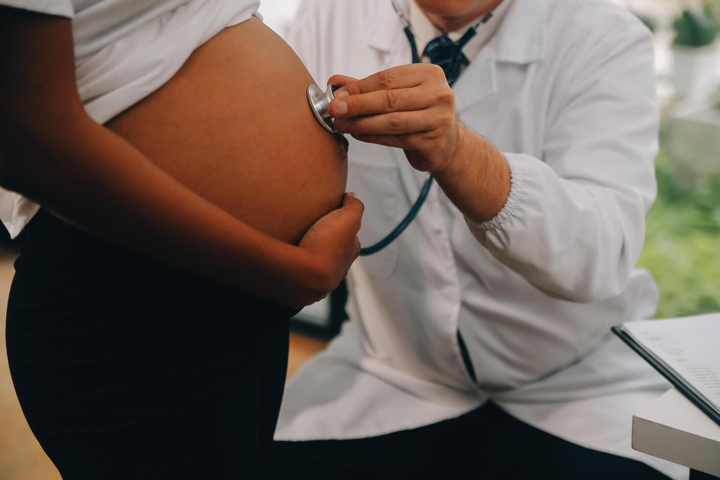 fêmea médico é verificação grávida mulher com estetoscópio. conceito carinhoso para grávida mulher foto