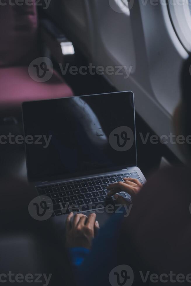 usando Móvel e computador portátil, pensativo ásia pessoas fêmea pessoa a bordo, avião janela, perfeitamente capturar a antecipação e excitação do feriado viagem. chinês, japonês pessoas. foto