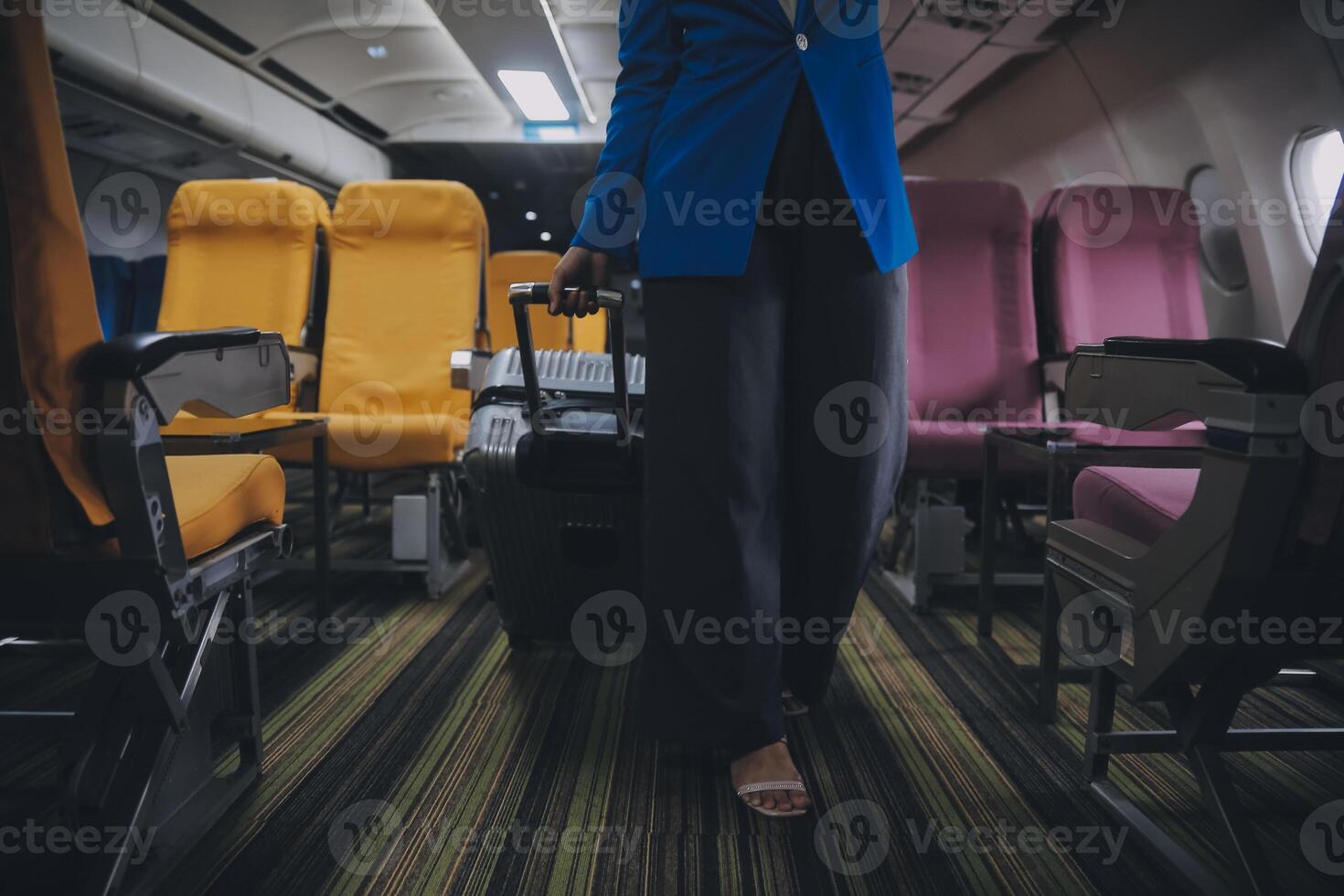 ásia fêmea viajante colocando bagagem para dentro a sobrecarga armário em avião durante embarque. foto