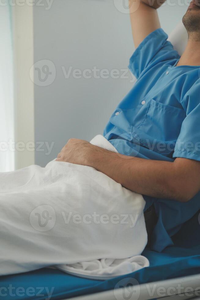 a sério eu vou homem deitado em uma cama dentro a hospital. monitores mostrar dele vital sinais. enfermaria é limpar \ limpo e novo. foto