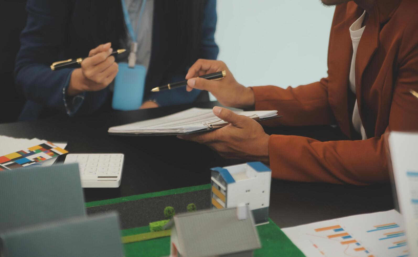 equipe do arquiteturas e empresários discutindo e debate em chão plano modificação para real Estado investimento e habitação desenvolvimento projeto foto