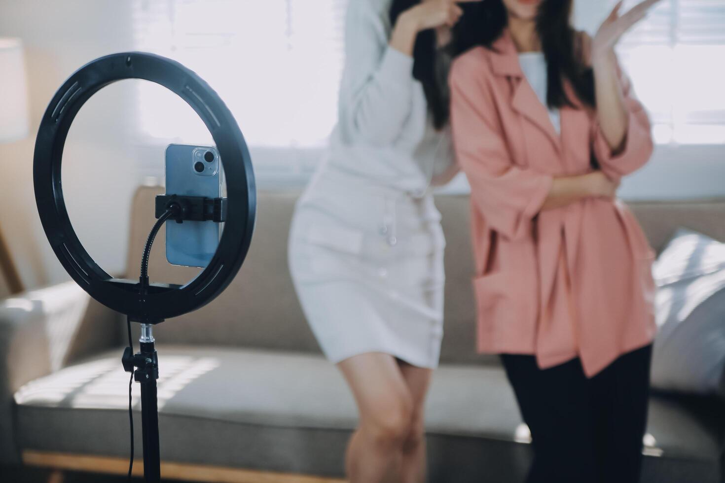 ásia jovem mulher com dela amigo tiktoker criada dela dançando vídeo de Smartphone Câmera junto. para compartilhar vídeo em social meios de comunicação inscrição foto