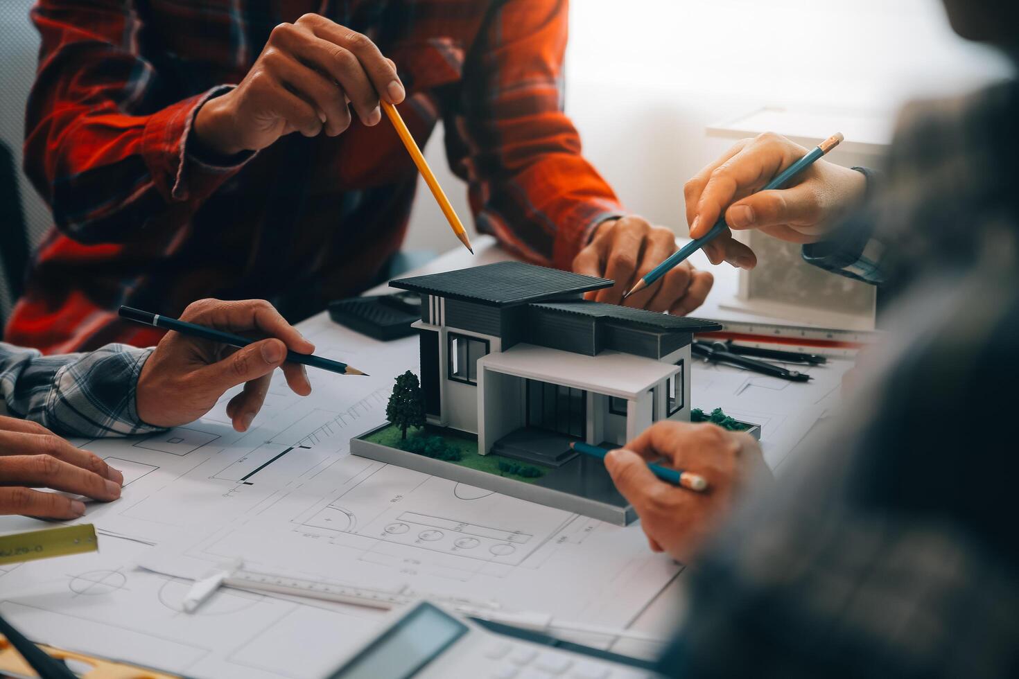 engenheiro pessoas encontro trabalhando e apontando às uma desenhos dentro escritório para discutindo. Engenharia Ferramentas e construção conceito. foto