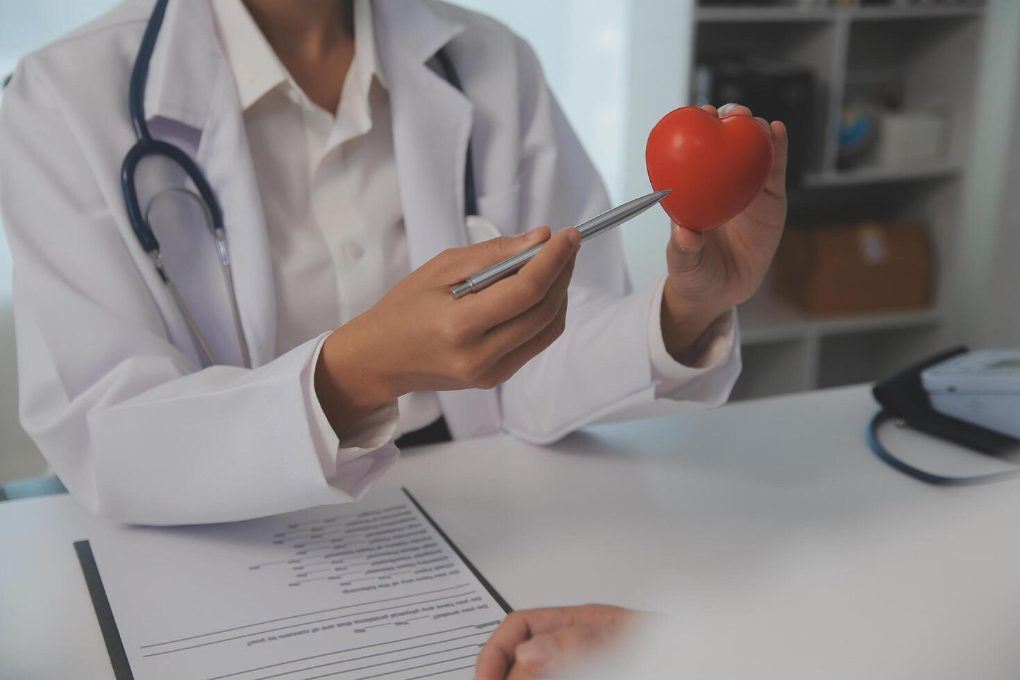 mãos do médico mulher segurando vermelho coração, mostrando símbolo do amor, humano Apoio, suporte para paciente, promovendo médico seguro, cedo checar para assistência médica, cardiologista ajuda. fechar acima do objeto foto