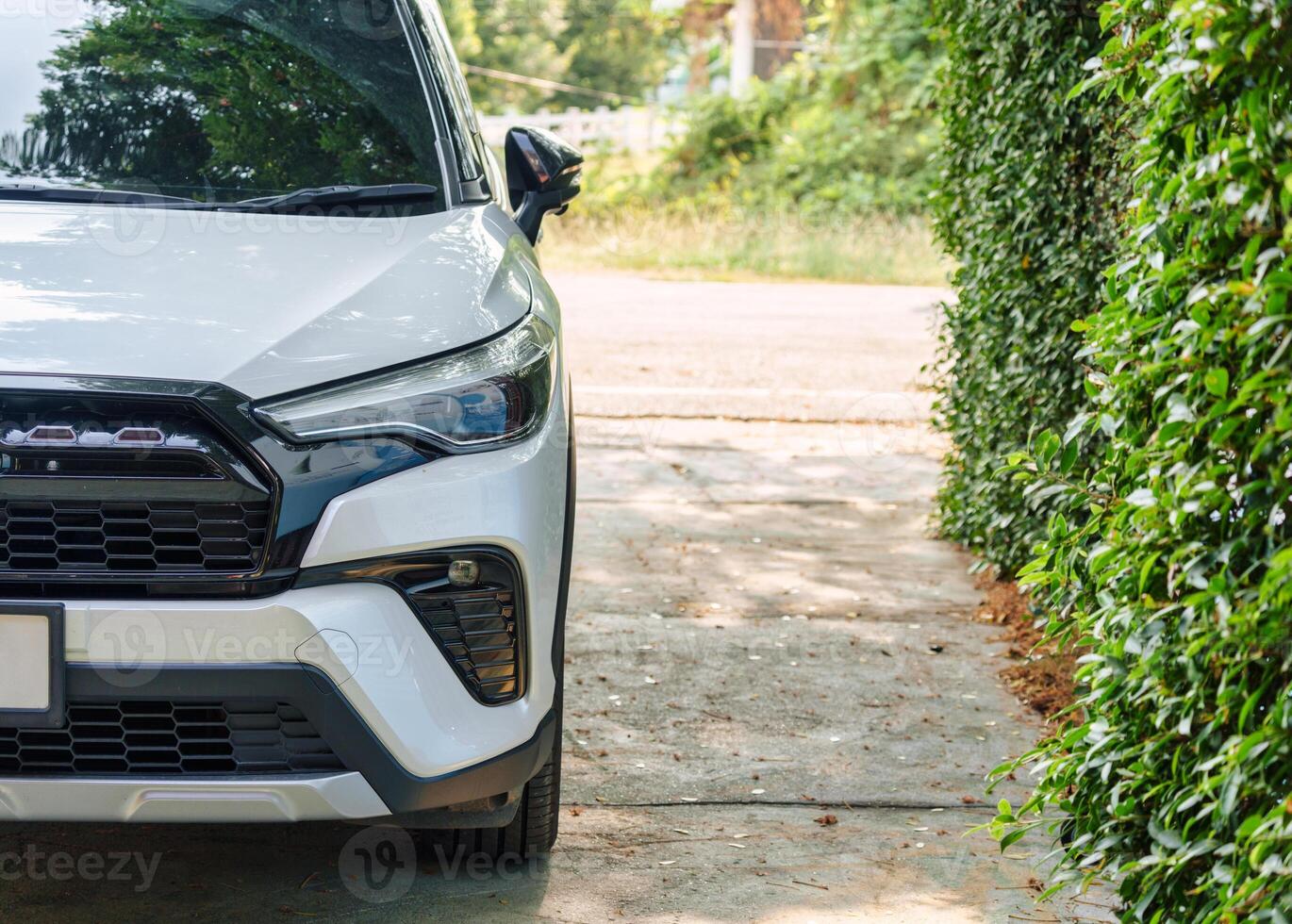 branco moderno suv carro Farol estacionado dentro Jardim foto