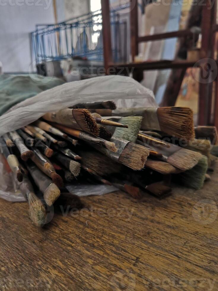 uma pilha do pintura escovas em uma de madeira mesa foto