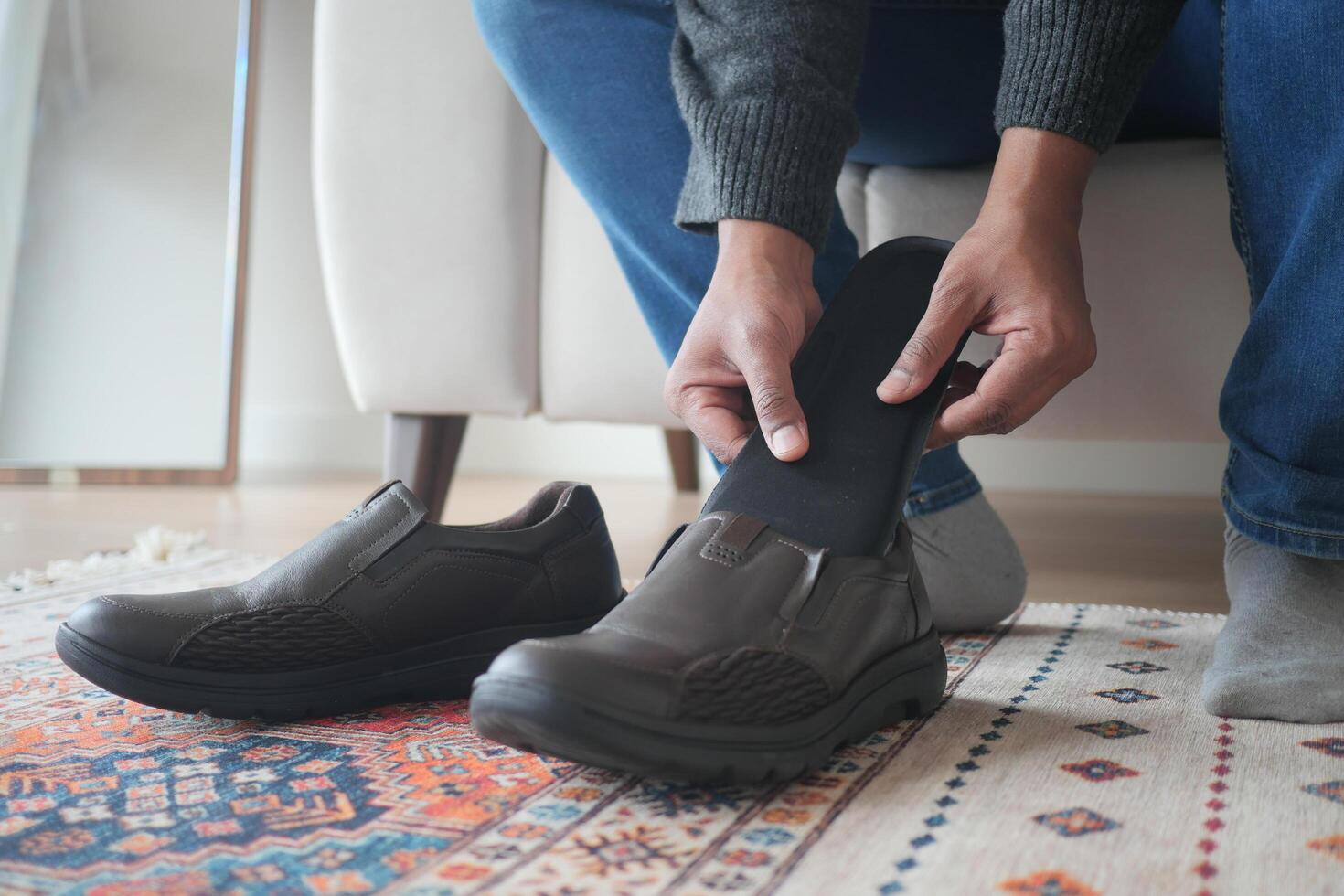 homens mão colocando ortopédico palmilhas dentro sapatos foto