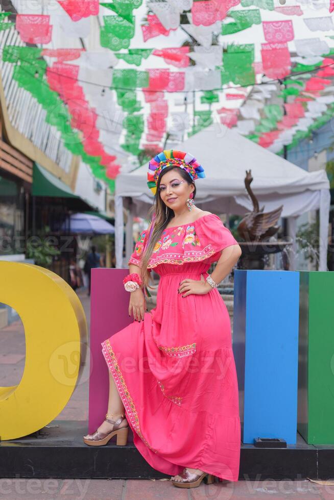 mexicano mulher vestindo tradicional traje Próximo para a gigante cartas do a cidade do colima. cinco de maionese celebração. foto