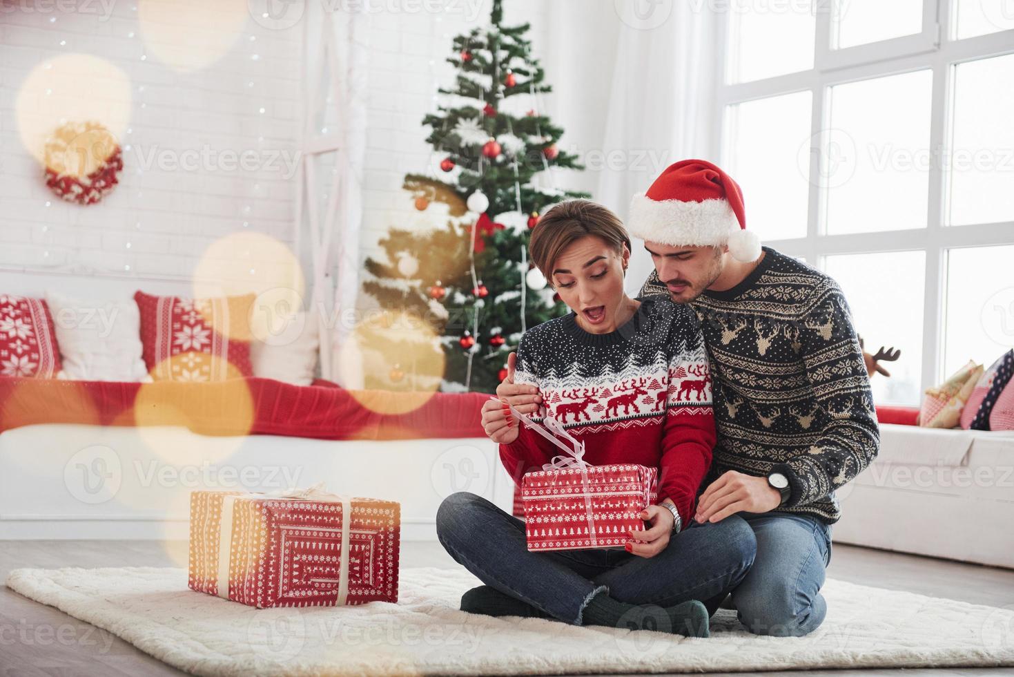 o que está aí. homem surpreende sua esposa para o natal no lindo quarto com decorações de Natal foto