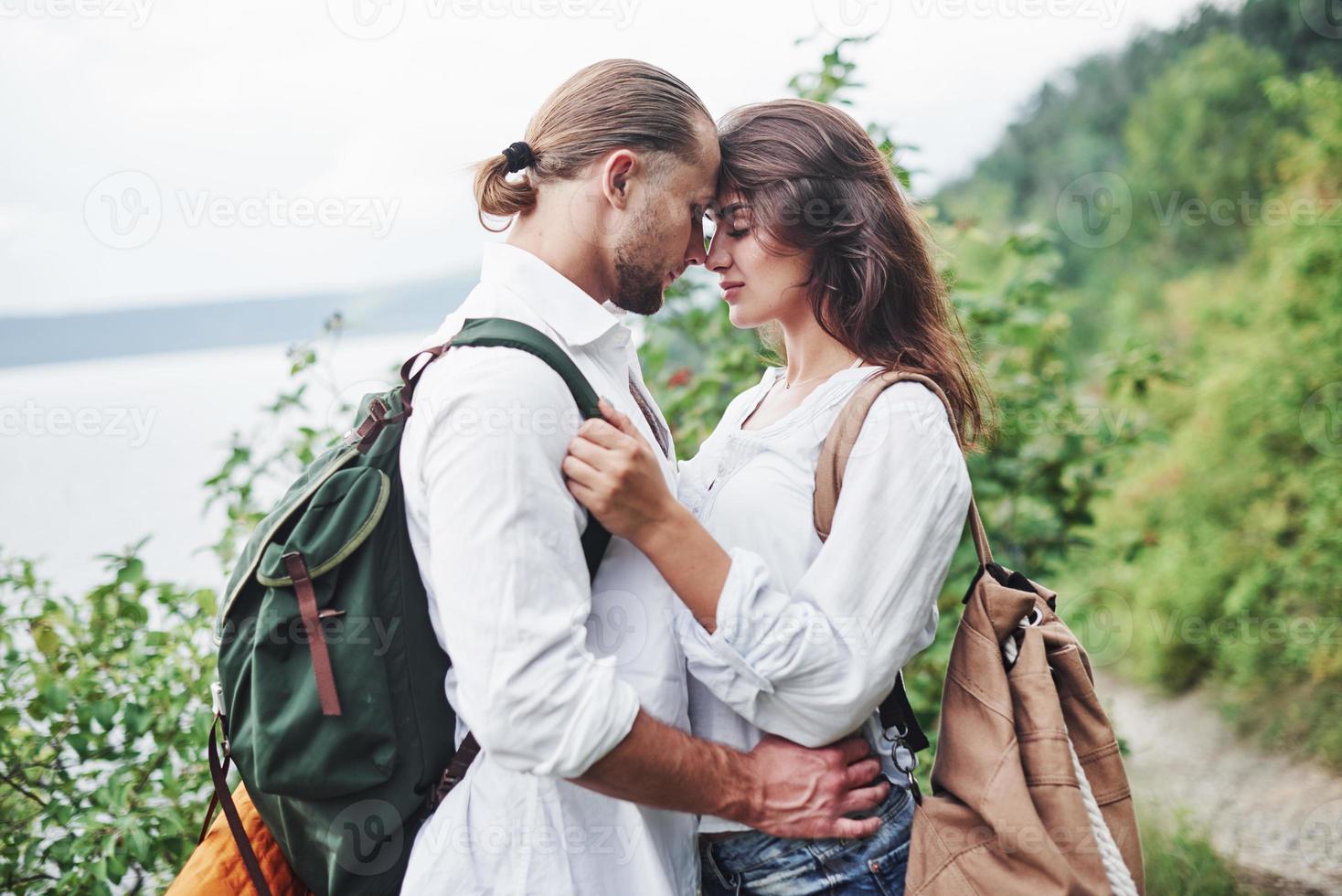 jovem casal decidiu passar as férias de forma ativa perto do lago ao fundo foto
