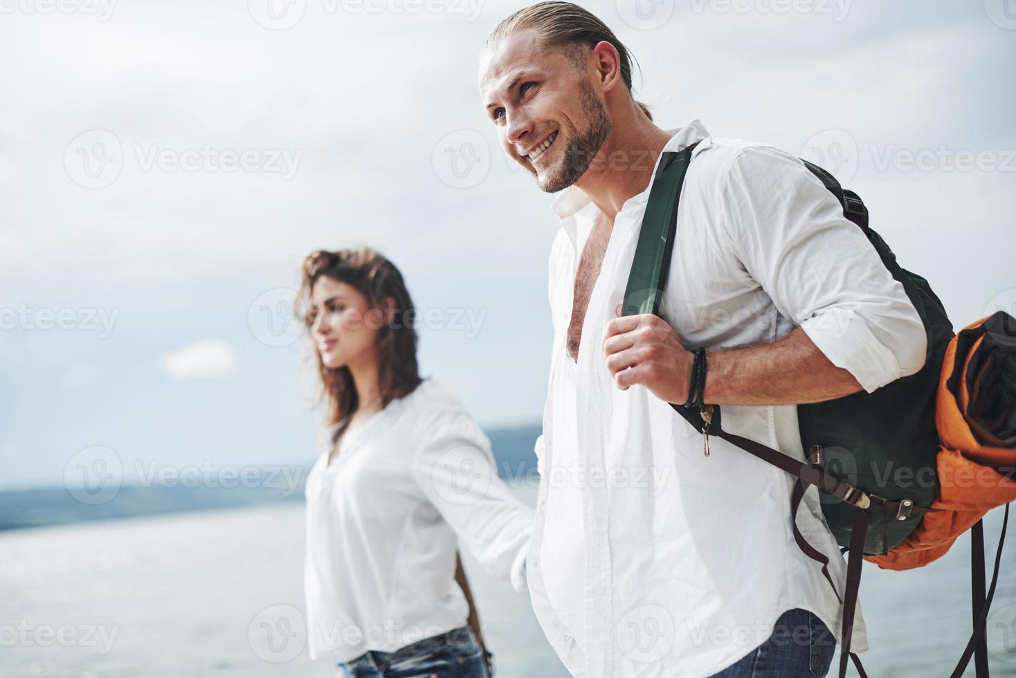 sorrindo e se sentindo feliz. caminhada alegre de lindo casal ao ar livre no fundo do lago foto