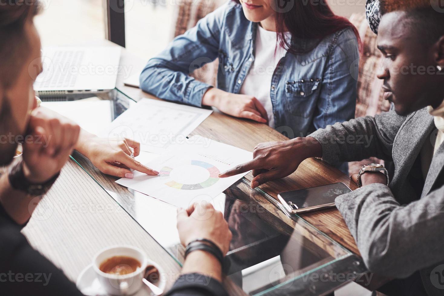 empreendedor de pessoas multi-étnicas, conceito de empresa de pequeno porte. mulher mostrando algo a colegas de trabalho no laptop enquanto eles se reúnem em torno de uma mesa de conferência foto