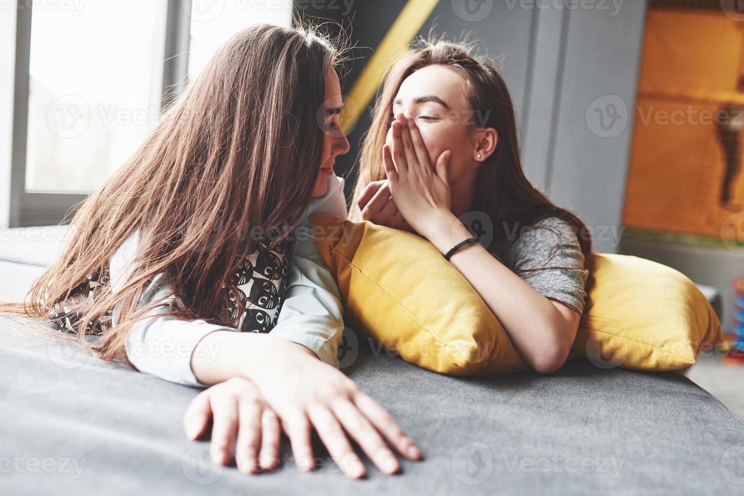 duas belas jovens irmãs gêmeas passando um tempo juntos com travesseiros. irmãos se divertindo em casa conceito foto