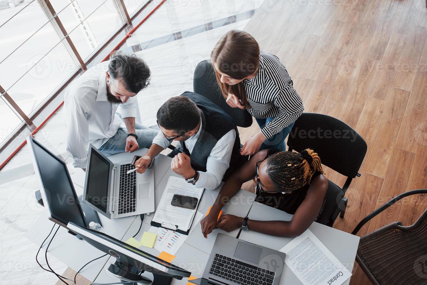 um grupo de pessoas multinacionais ocupadas trabalhando no escritório. foto