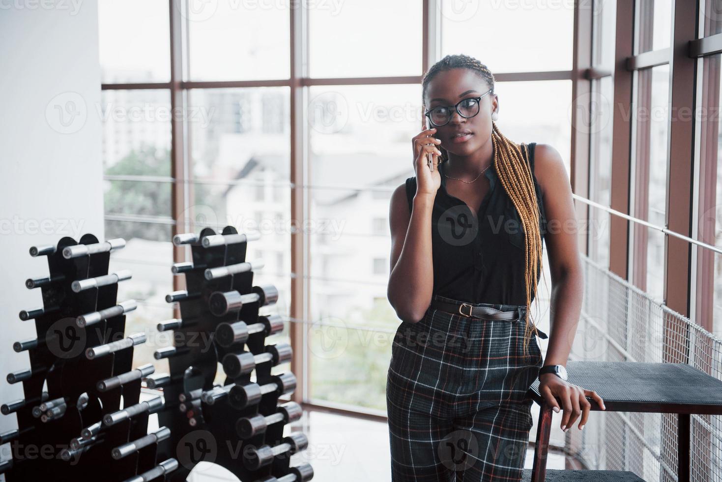 uma mulher de negócios americana fala ao celular no escritório. foto