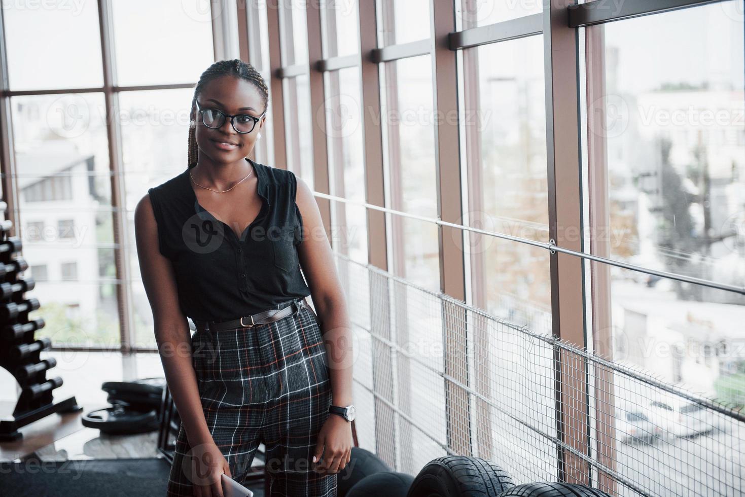 uma jovem mulher afro-americana com roupas elegantes. foto