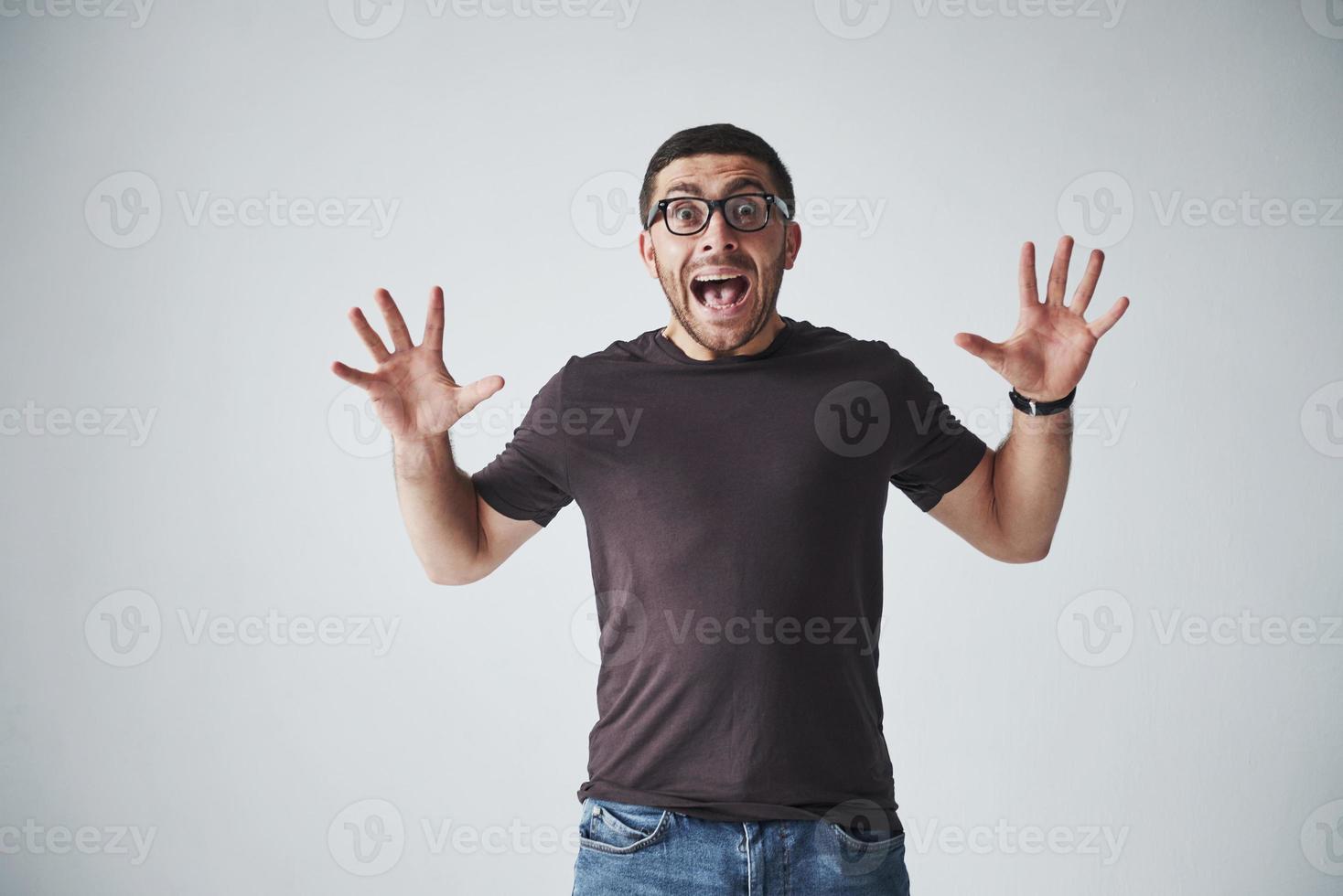 O homem emocional em roupas casuais grita de dor ou medo. seus sentimentos são opressores foto