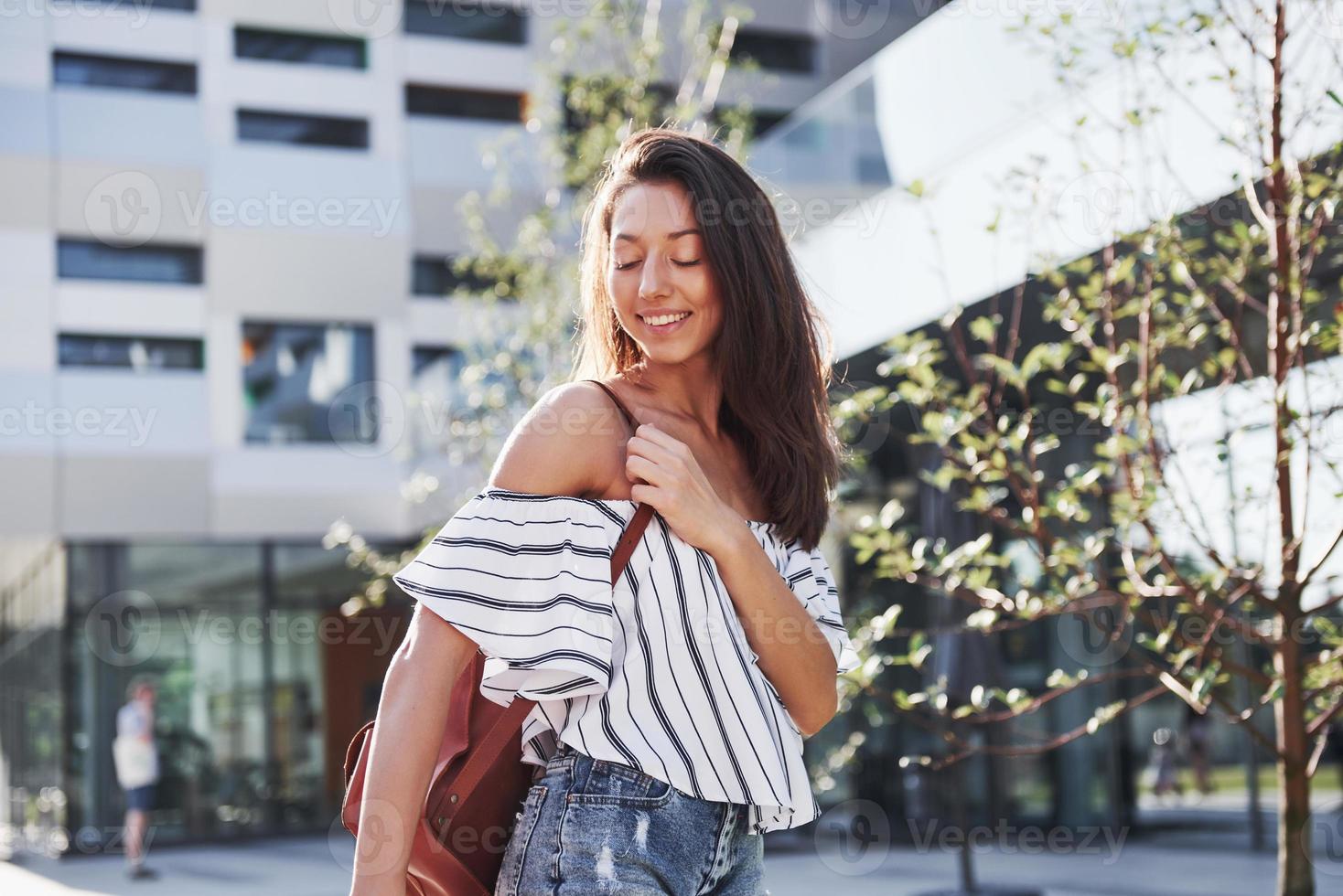 linda e feliz aluna jovem com mochila perto do campus da Universidade. conceito de educação e lazer foto