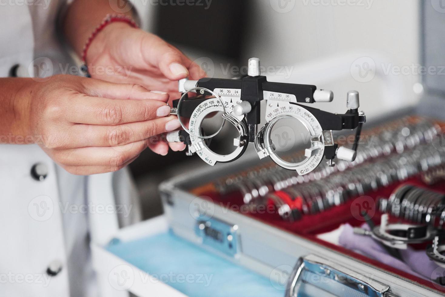 mudar as lentes. mãos femininas segurando o dispositivo óptico para teste de visão foto