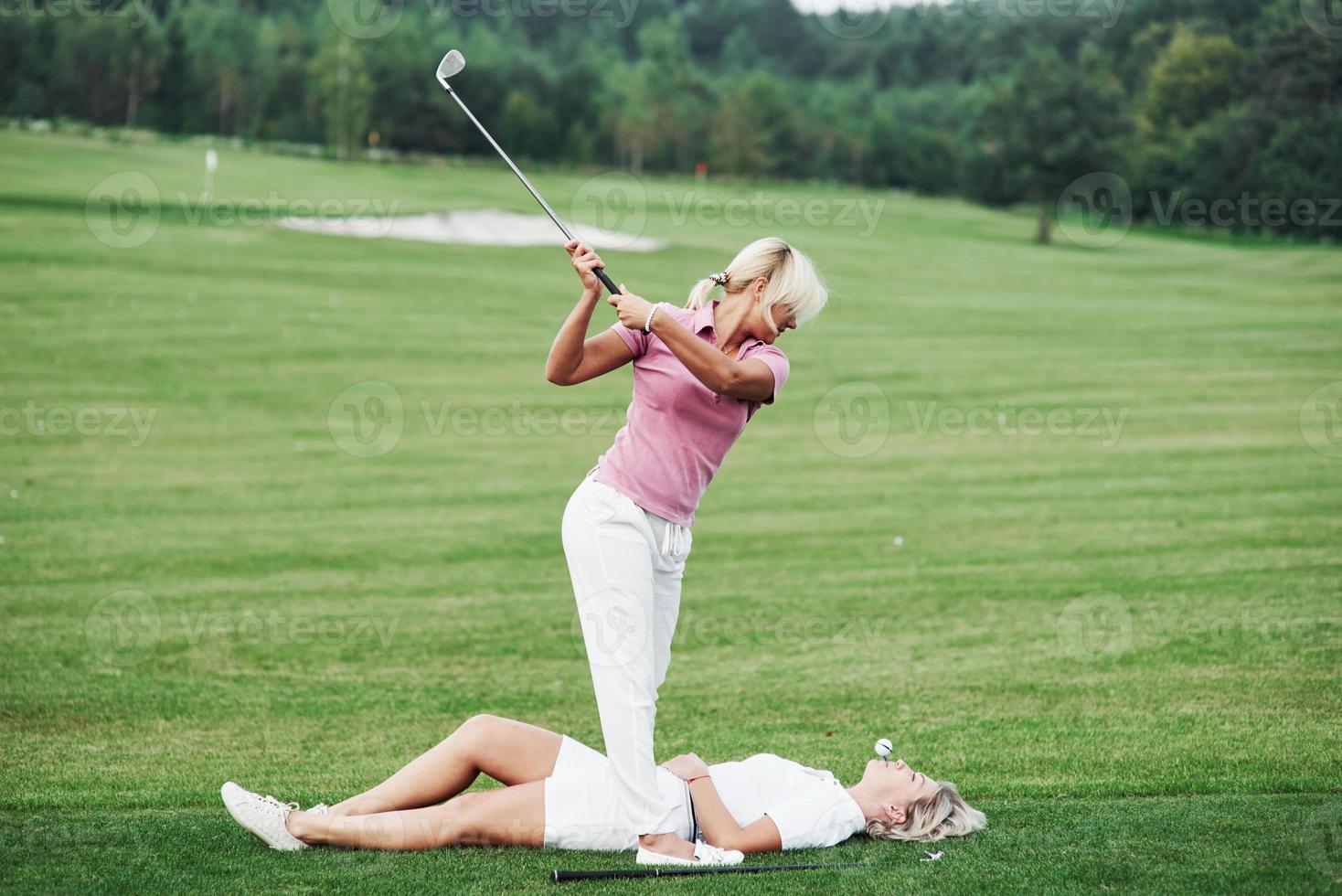 duas mulheres decidem jogar golfe de uma maneira um pouco diferente. tente isso é por sua própria conta e risco foto