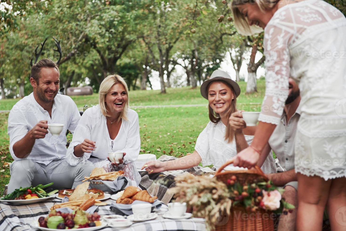 o que você trouxe para nós. grupo de amigos adultos descansa e conversa no quintal do restaurante na hora do jantar foto