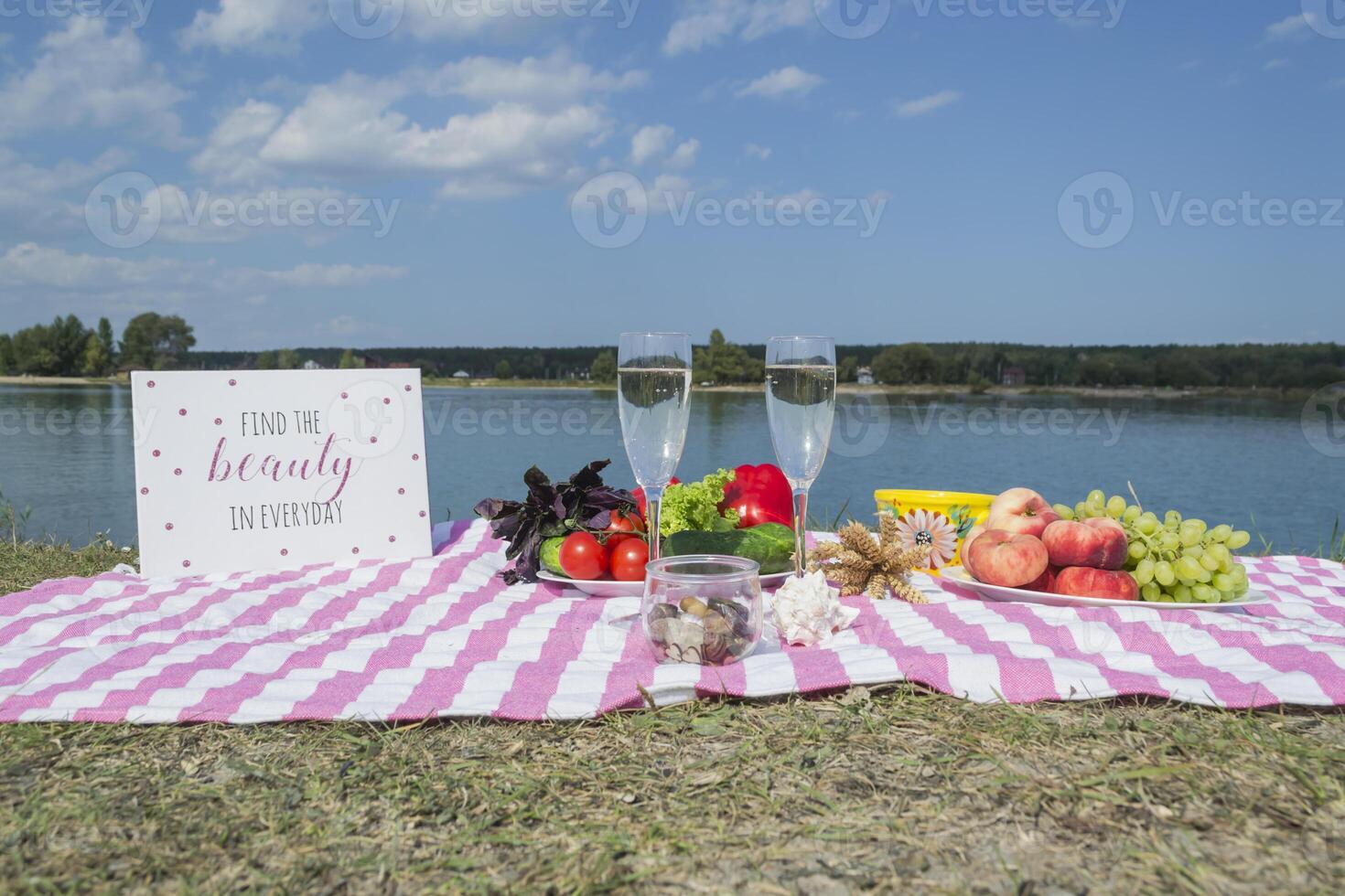 lindo piquenique com frutas, legumes e óculos do vinho perto lago. foto