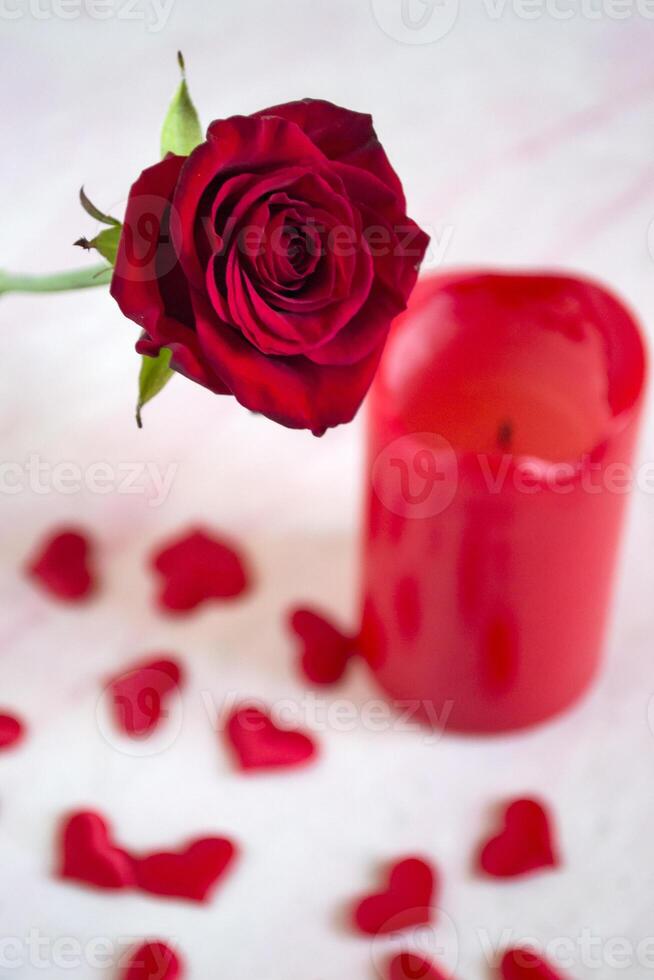 vermelho rosa, corações e vela em uma mesa. foto