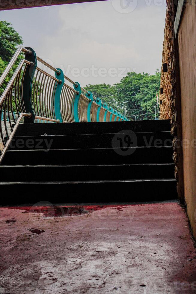 fechar Visão do a escadas conduzindo para a jardim com a cerca dividindo a rio. foto