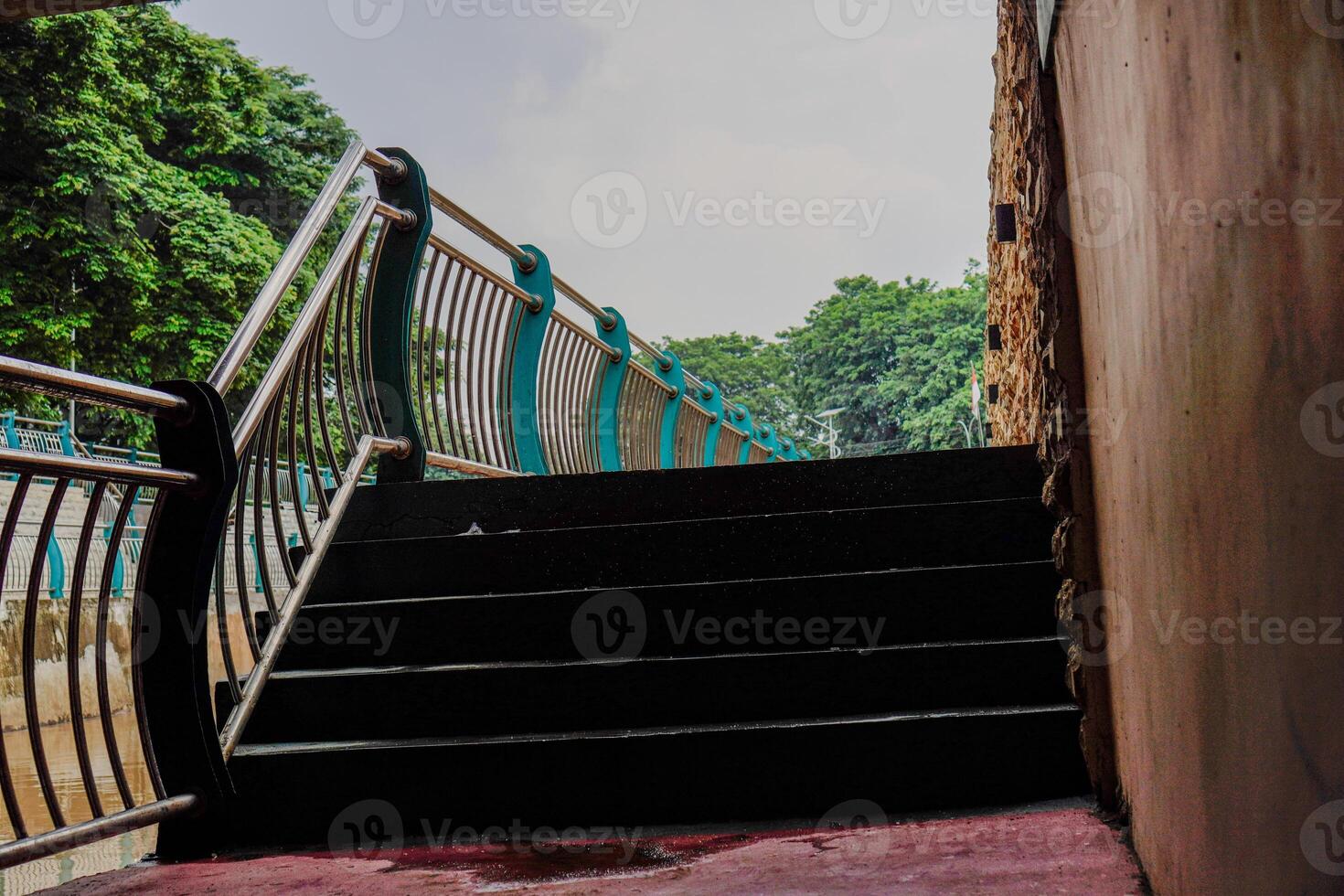 fechar Visão do a escadas conduzindo para a jardim com a cerca dividindo a rio. foto