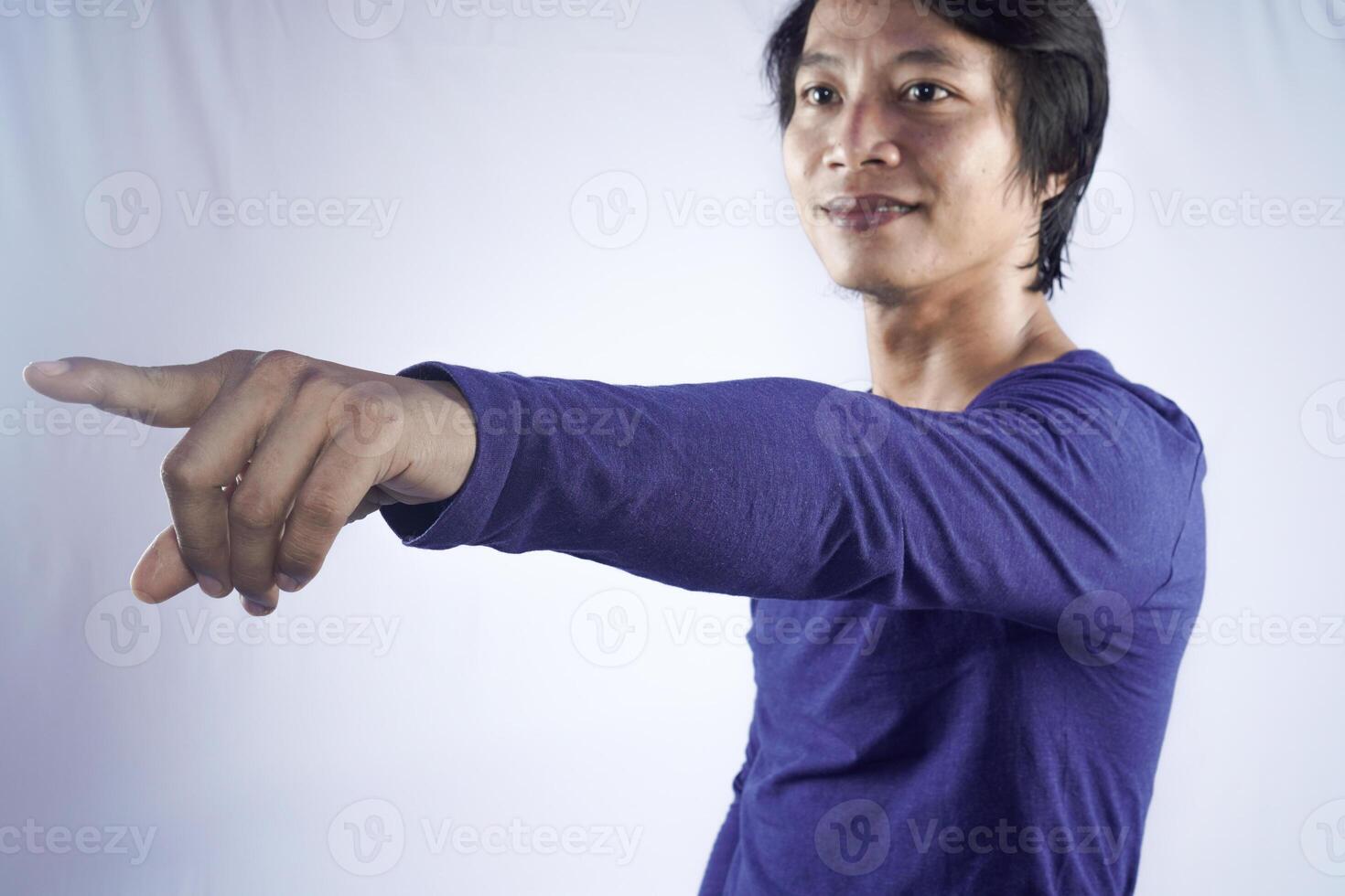 fechar acima foto do alegre bonito homem à moda em linha reta grandes manga azul roupas, apontando às esvaziar espaço isolado em branco cor fundo.