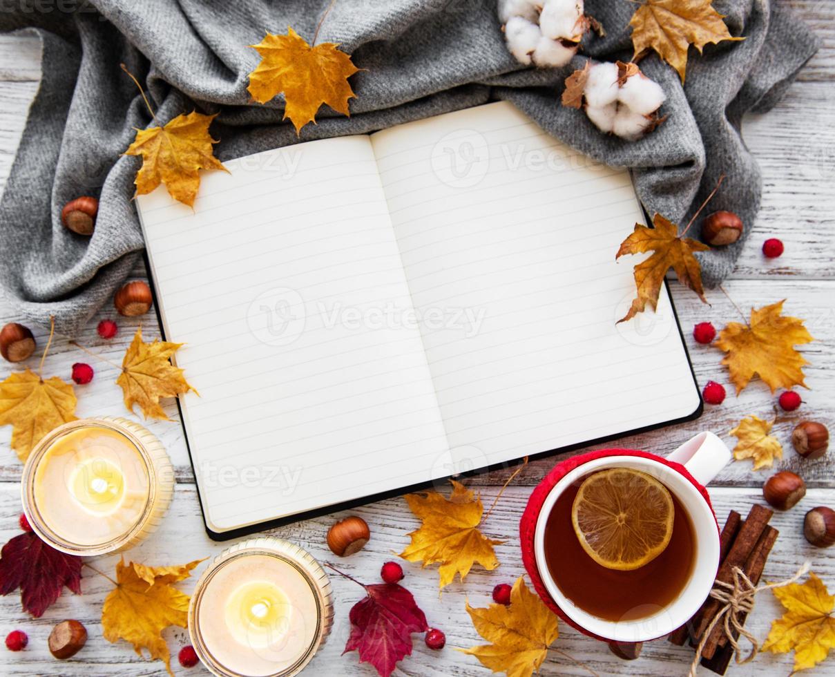 outono plano deitado com caderno, xícara de chá e folhas foto