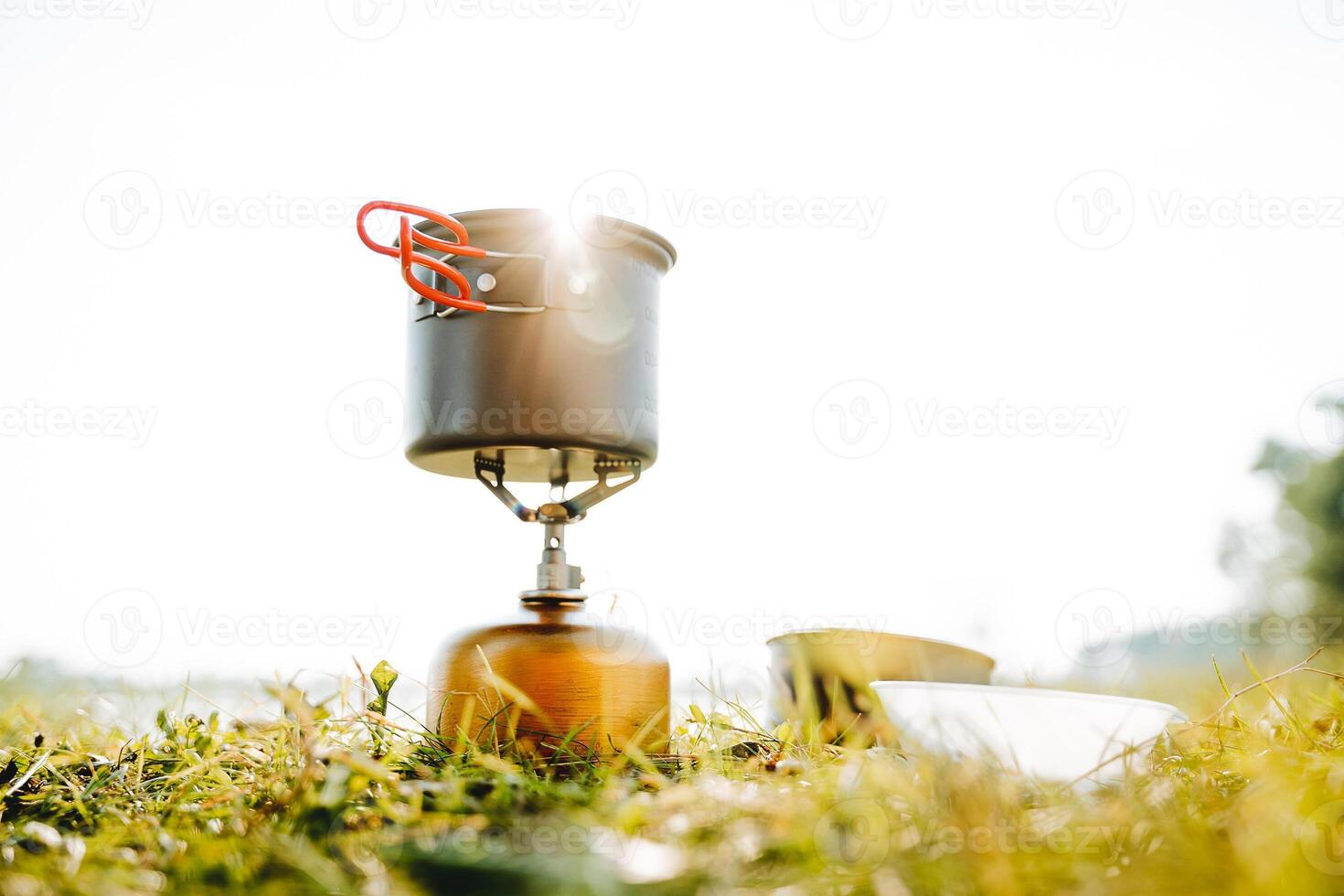 utensílios em uma acampamento viagem para cozinhar em uma queimador, brilho do luz solar brilho através uma Panela, caminhada através a montanhas, cozinhando sopa dentro natureza, uma só caminhada. foto