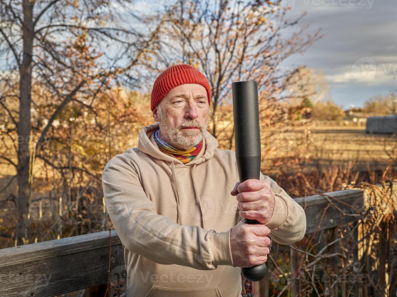 Senior homem é exercício com uma aço indiano clube foto