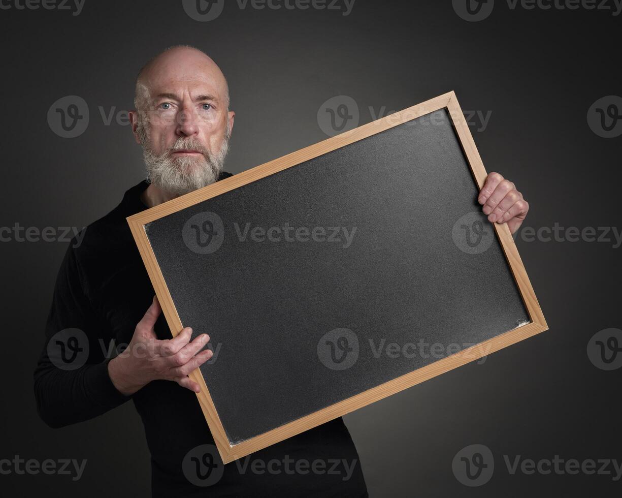 Senior homem com em branco quadro-negro borda foto