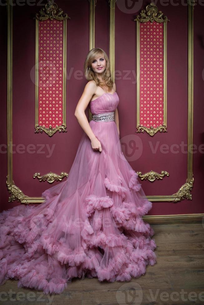 retrato de uma jovem mulher bonita em um vestido longo rosa foto