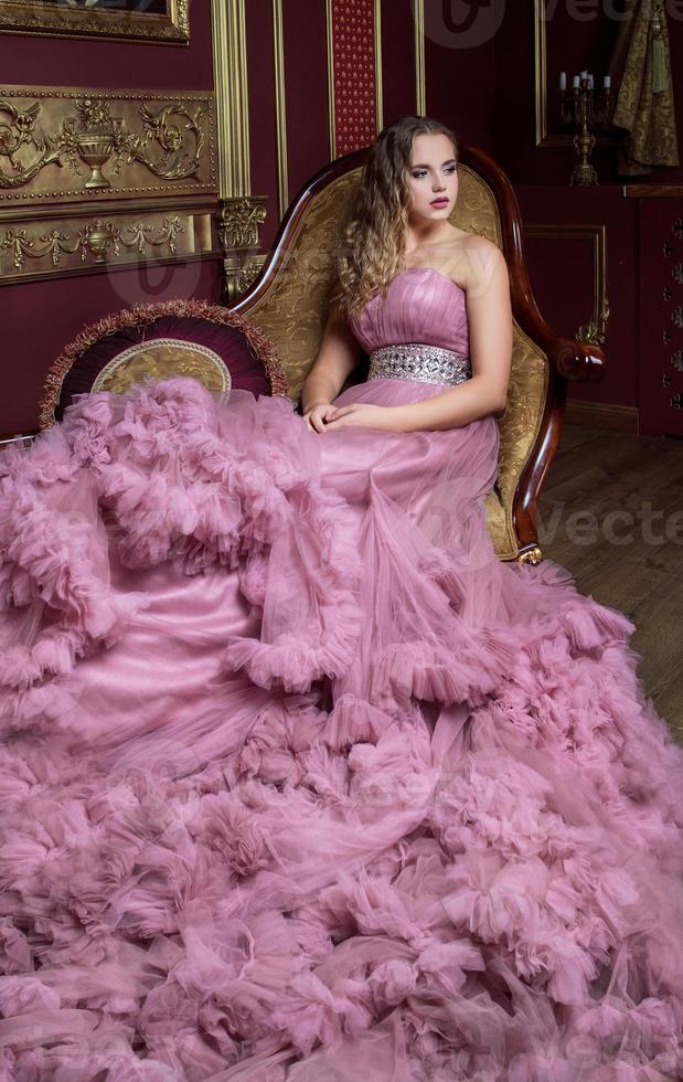 retrato de uma jovem mulher bonita em um vestido longo rosa foto