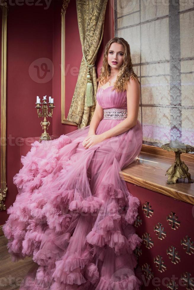 retrato de uma jovem mulher bonita em um vestido longo rosa foto