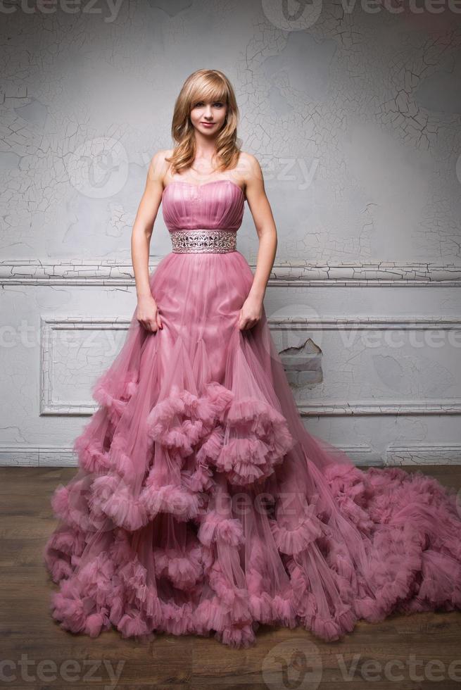 retrato de uma jovem mulher bonita em um vestido longo rosa foto