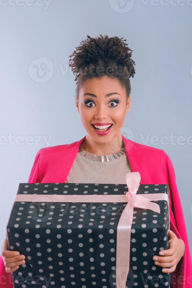 Mulher afro-americana feliz e alegre com caixa de presente foto