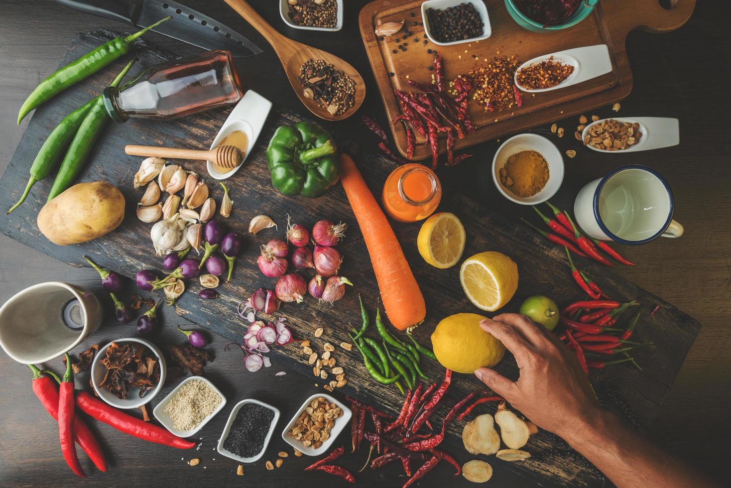 alimentos saudáveis ervas especiarias para uso como ingredientes culinários em um fundo de madeira com vegetais orgânicos frescos na madeira. o conceito de ingredientes alimentares com variedade na mesa rústica. foto