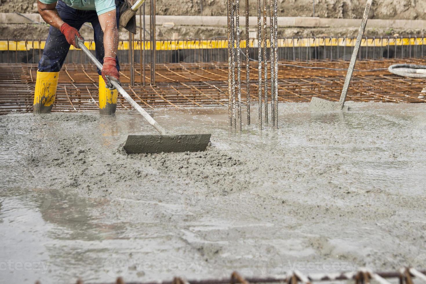 um pedreiro que nivelou o concreto recém-derramado para lançar as fundações de um edifício foto