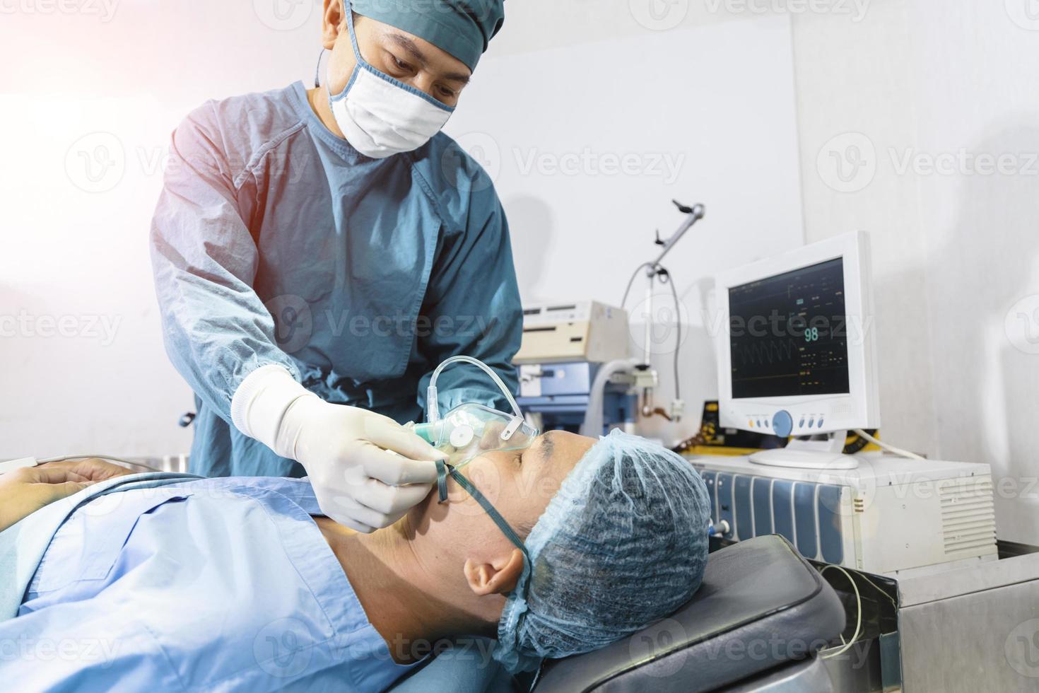 o cirurgião assistente colocou o paciente em uma máscara de ventilador de oxigênio em preparação para a cirurgia. foto