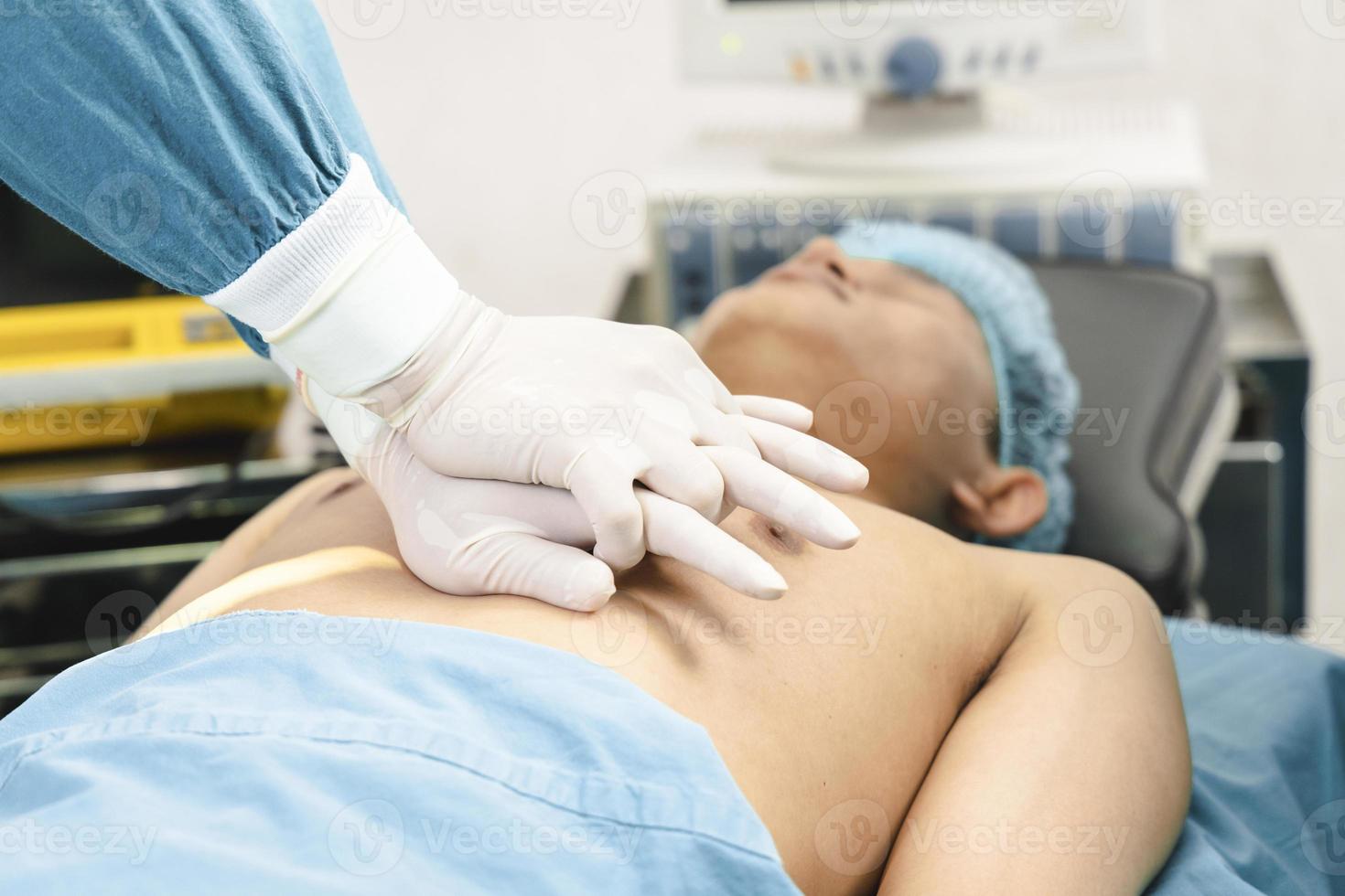 cirurgião e assistente fazendo cpr no paciente na sala de cirurgia. emergência de primeiros socorros - ressuscitação cardiopulmonar foto