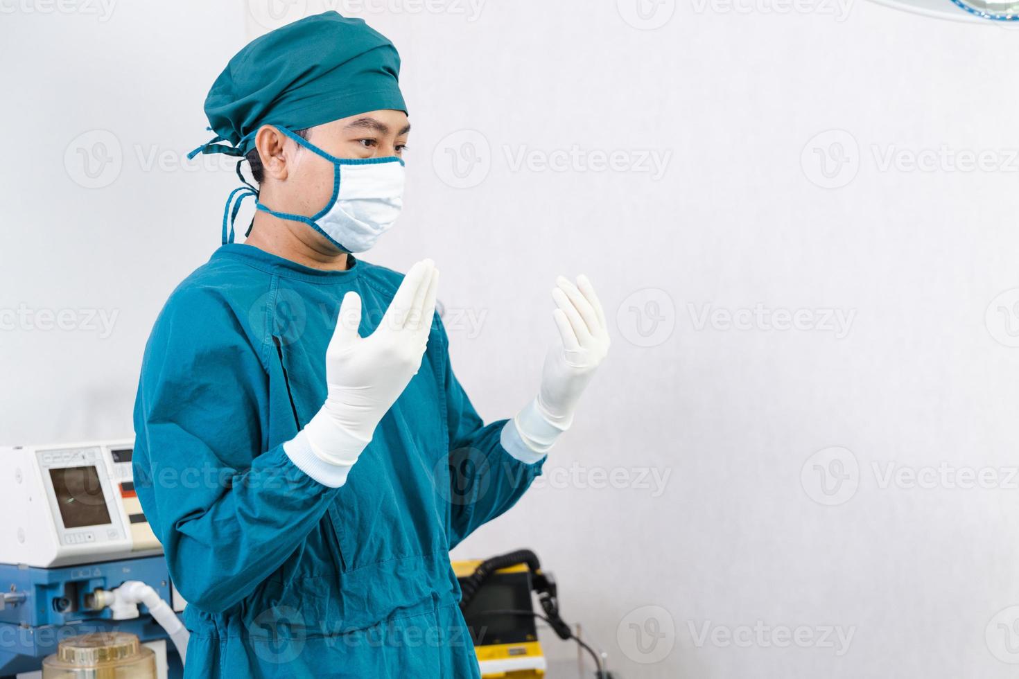 médico usando luvas, preparando-se antes da cirurgia na sala de cirurgia foto