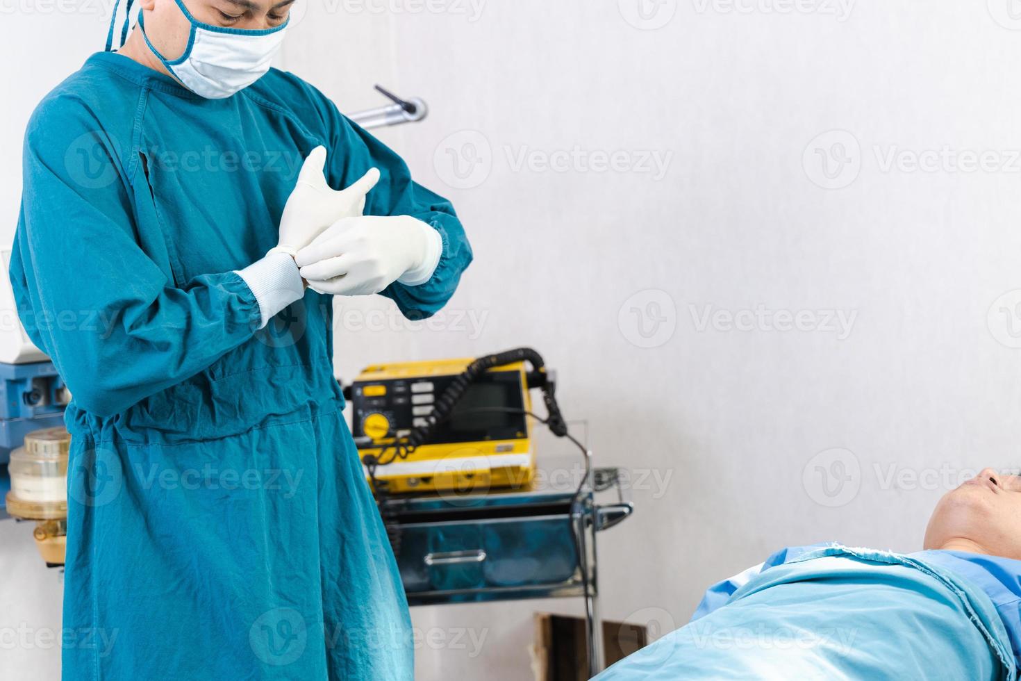 médico usando luvas, preparando-se antes da cirurgia na sala de cirurgia foto