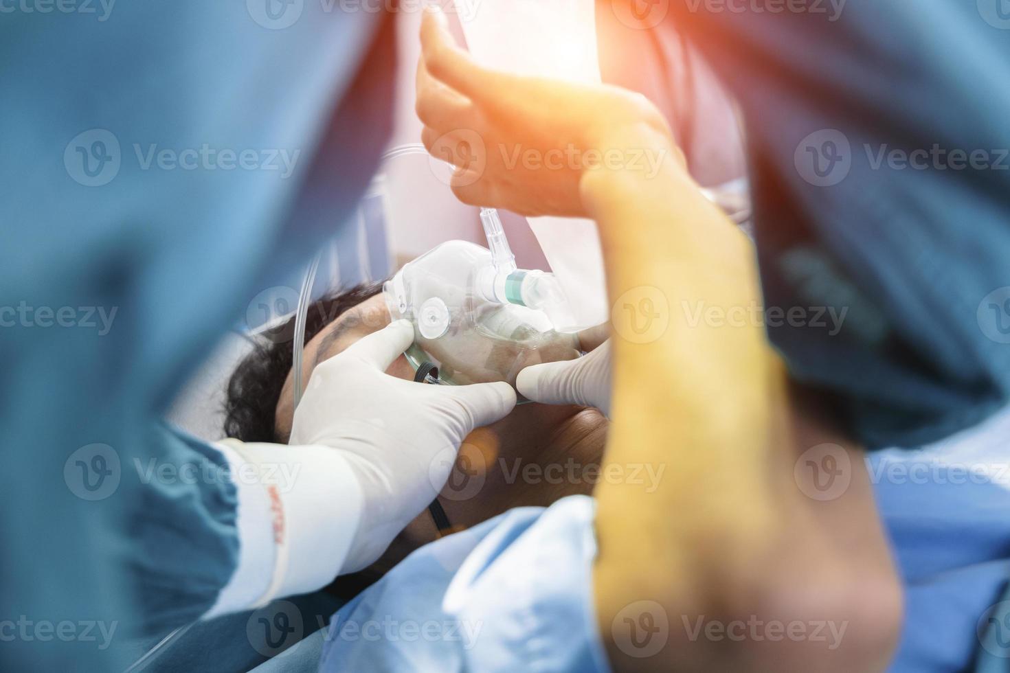 o cirurgião assistente colocou o paciente em uma máscara de ventilador de oxigênio em preparação para a cirurgia. foto
