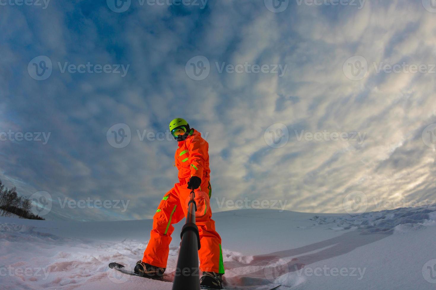 snowboarder com a prancha de snowboard fazendo uma selfie foto