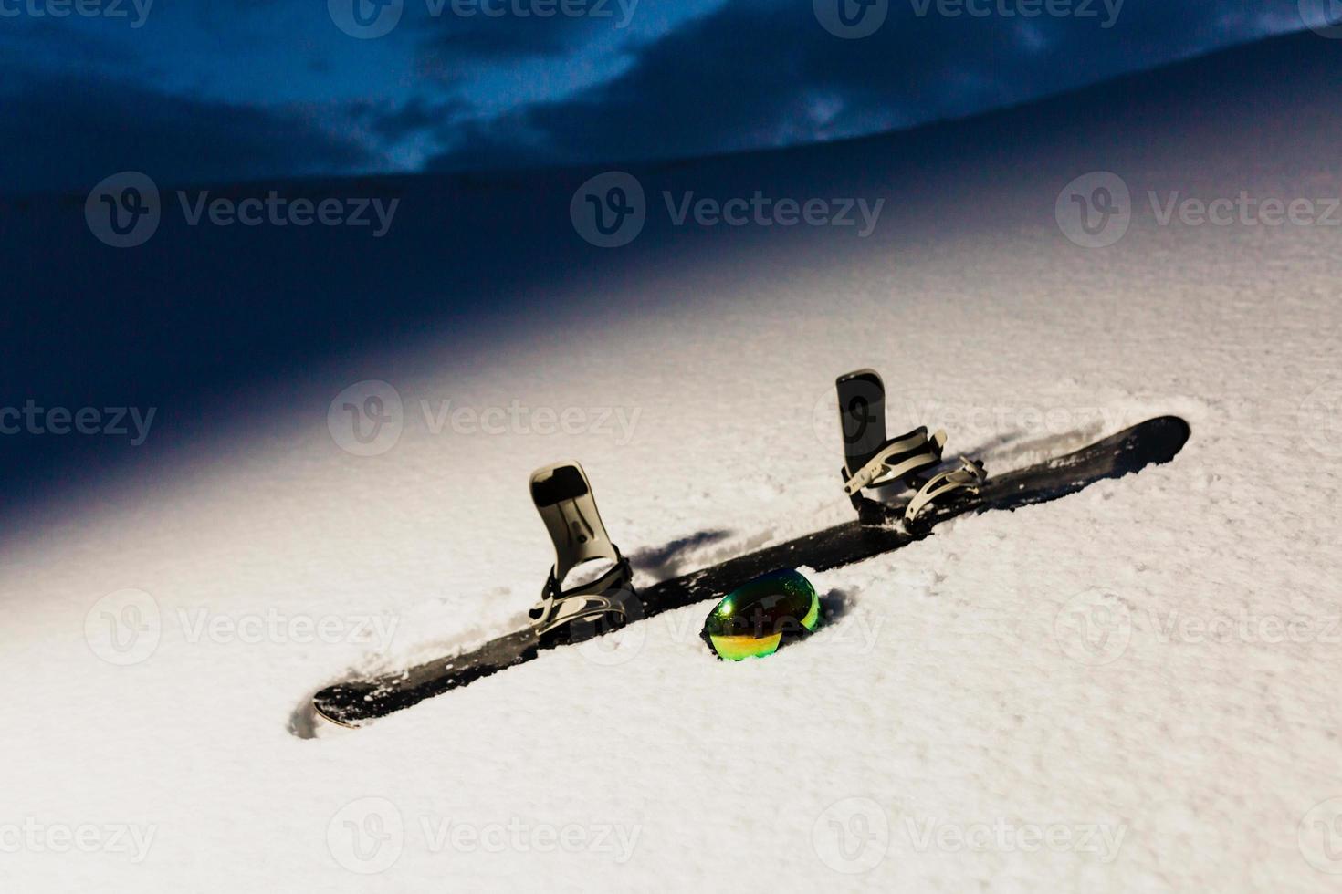 textura em pó e equipamentos para snowboard ao pôr do sol foto