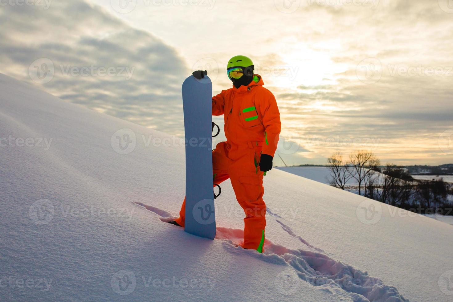 snowboarder ao fundo do pôr do sol foto