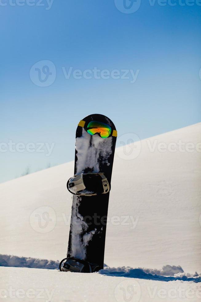 snowboard e googles de esqui na neve perto da pista de freeride foto